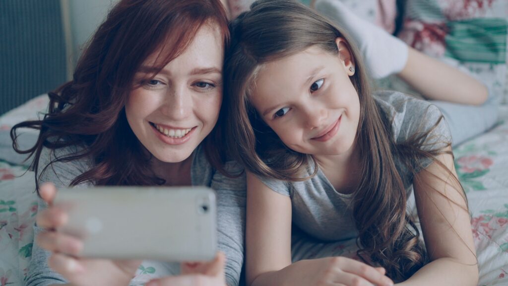 child and parent watching video on phone