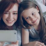 child and parent watching video on phone